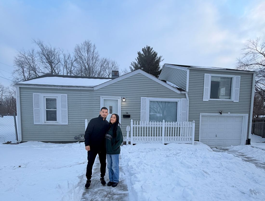 The owners of Golden Hour Offers in front of a home they purchased